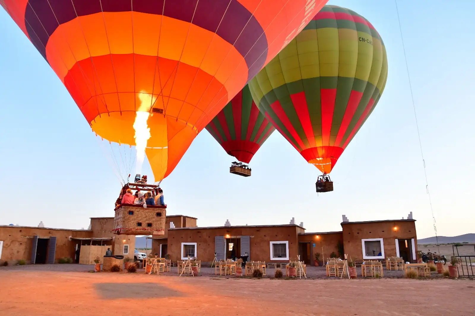 Hot air balloon flying over Marrakech's Palm Grove at sunrise